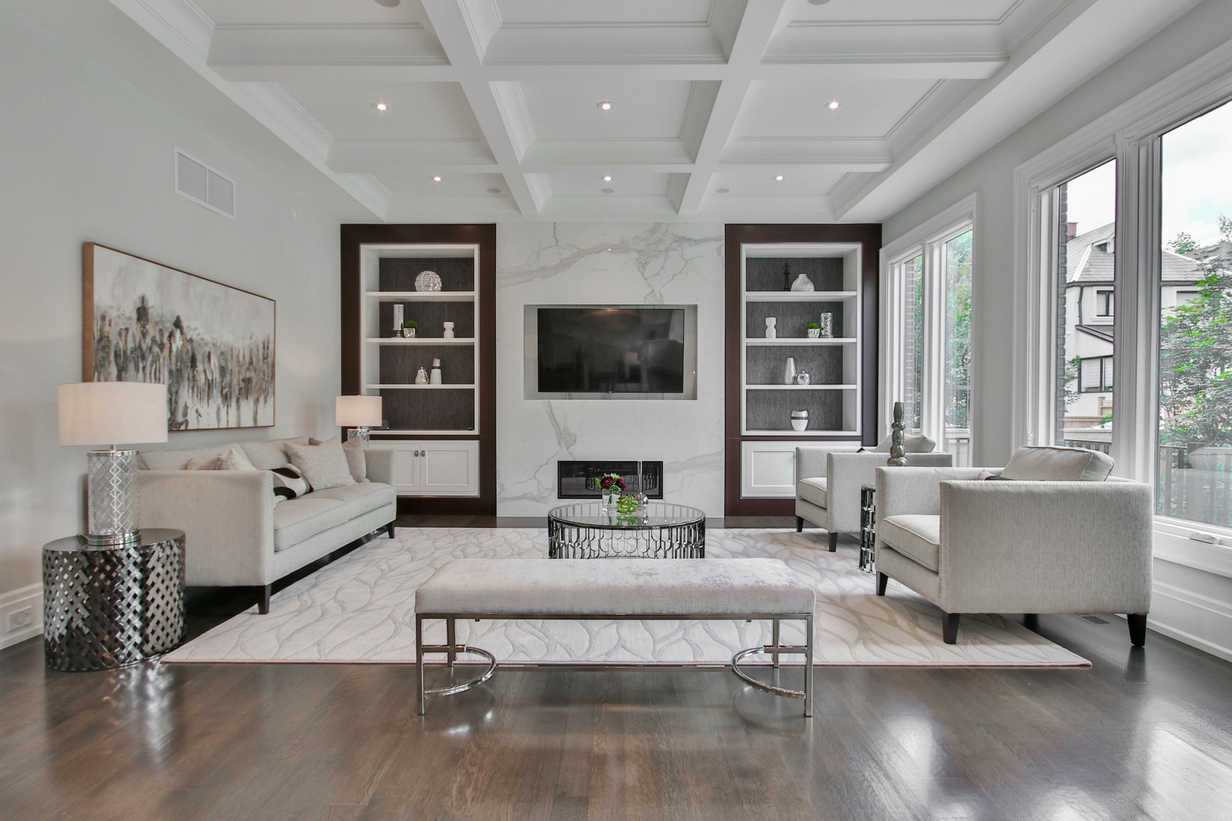Bright living room with sofas and a marble fireplace.
